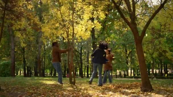 暖かい日差しを楽しむ両親の娘の残りの秋の公園。気楽な週末 - 映像、動画