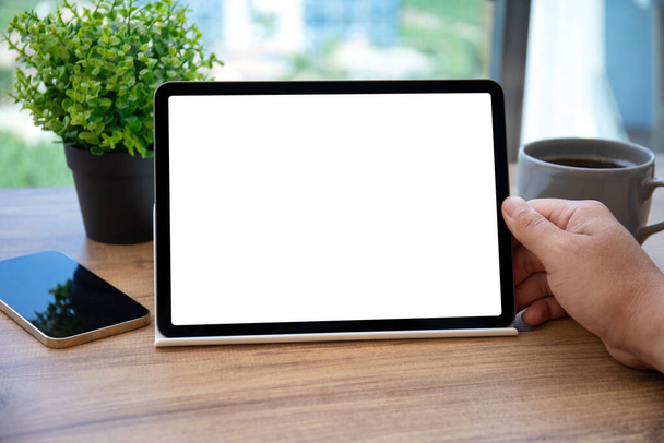 male hands holding computer tablet with isolated screen over table in office  - Foto, Imagen