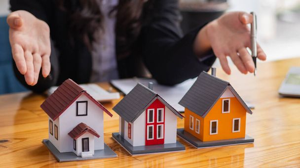 Commercianti immobiliari stanno introducendo modelli di casa per aiutare i clienti a prendere decisioni di acquisto e firmare gli acquisti, così come l'assicurazione casa e proprietà per la sicurezza della loro casa e della famiglia. - Foto, immagini
