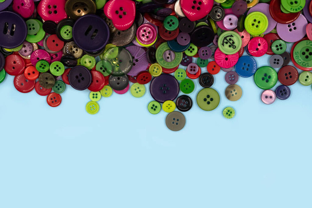 Colored sewing buttons composition on green pastel background. Flat lay with copy space. High quality photo - Photo, Image