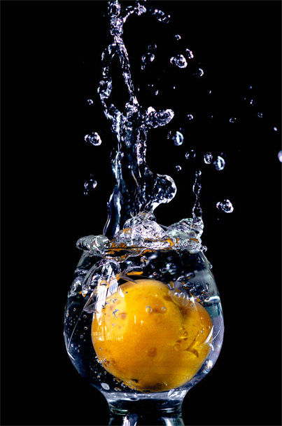 桃がコップ一杯の水に落ちた  - 写真・画像