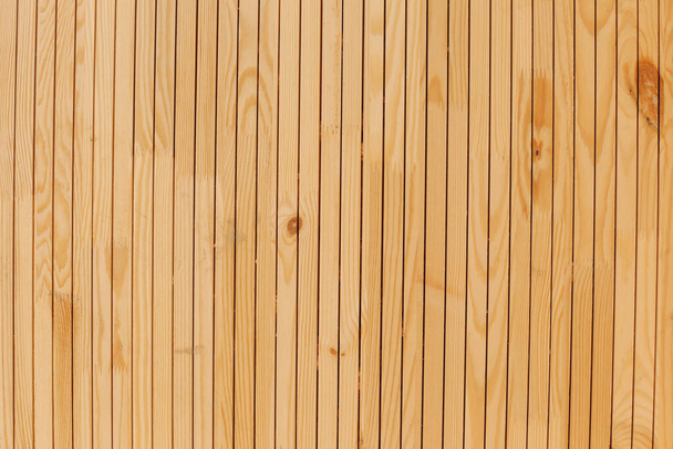A brownish-yellow full-screen wooden wall. Consisting of flat boards. - Foto, Bild