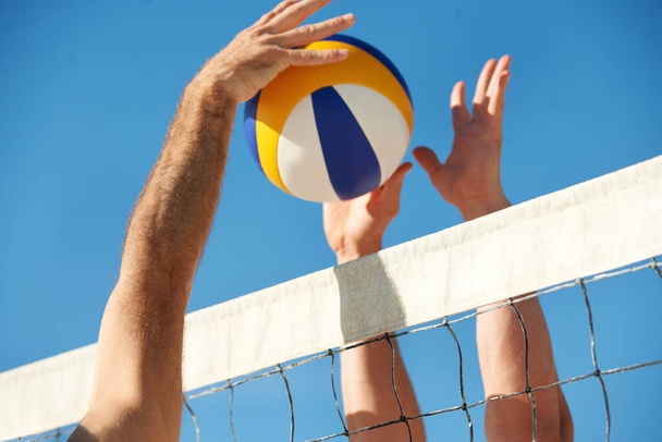 Its anyones point now. Shot of a beach volleyball game on a sunny day. - Foto, Bild