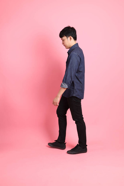 The young adult Asian man standing on the pink background. - Foto, Imagem