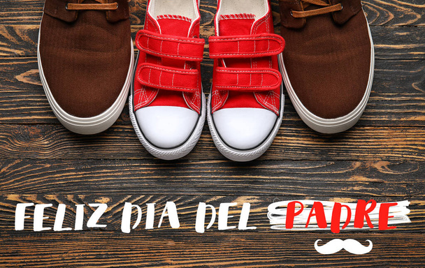 Wenskaart voor Internationale Vaderdag met schoenen van papa en zoon op houten achtergrond - Foto, afbeelding