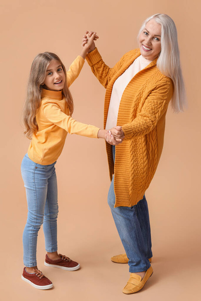 Bambina con la nonna su sfondo beige - Foto, immagini