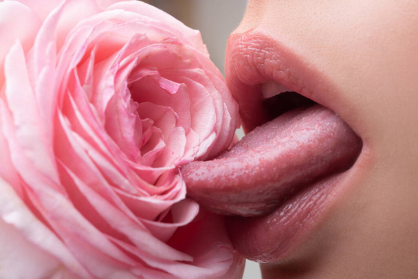 Lips with lipstick closeup. Beautiful woman lips with rose. Girl blowjob with tongue, vagina symbol. - Fotó, kép