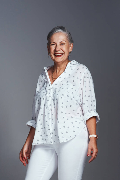 Your smile can change the world. Studio shot of a senior woman posing against a grey background. - Foto, Imagen