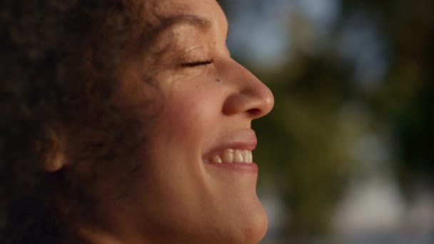 Boldog afro-amerikai nő élvezi meleg arany napfény szabadban portré. - Felvétel, videó
