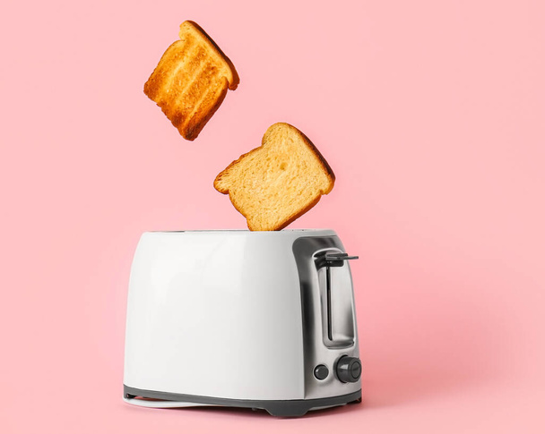 Modern toaster with bread slices on pink background - Photo, Image