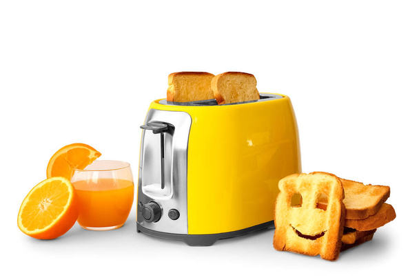 Moderni leivänpaahdin leipäviipaleilla ja lasillisella appelsiinimehua kevyellä taustalla - Valokuva, kuva