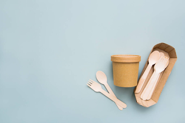 Zero waste, environmentally friendly, disposable, cardboard, paper utensils on a blue background. View from the top. Eco craft paper tableware. Copy space. - Foto, Bild
