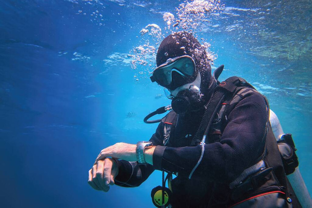 Uomo completamente attrezzato subacqueo subacqueo subacqueo nell'acqua blu  - Foto, immagini