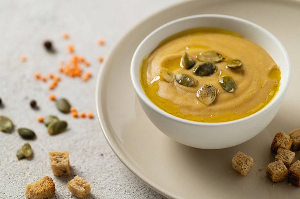 kremowa zupa wegetariańska z soczewicy i champignons na jasnym tle z nasionami i grzankami - Zdjęcie, obraz