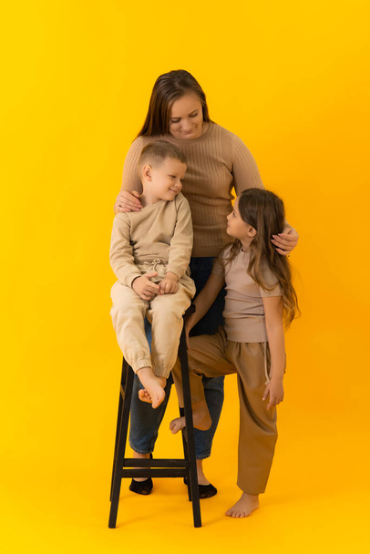 Mom is hugging her children, smiling, and looking at each other - Фото, изображение