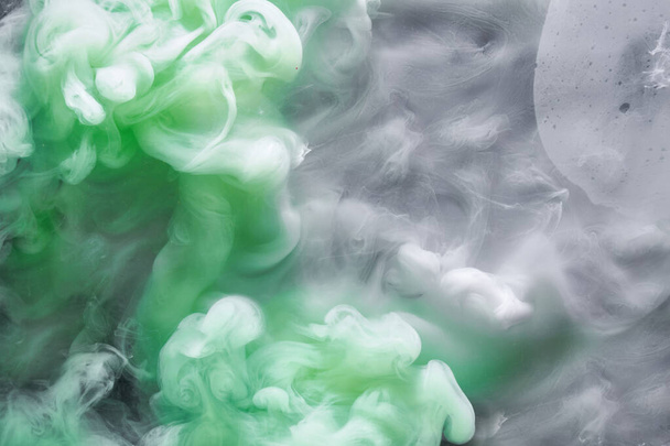 Green smoke on white ink background, colorful fog, abstract swirling emerald ocean sea, acrylic paint pigment underwater - Foto, Imagem