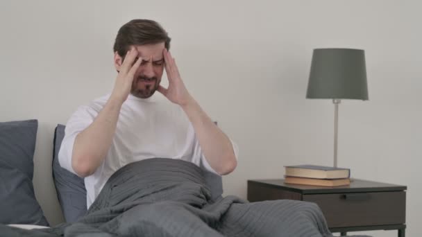 Junger Mann hat Kopfschmerzen beim Schlafen im Bett - Filmmaterial, Video