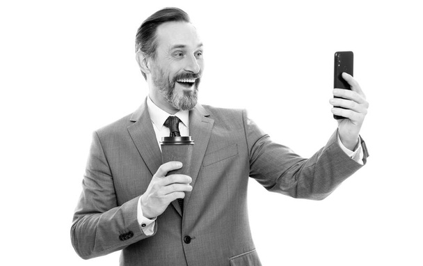 onnellinen mies bloggaaja puku meking selfie puhelimessa ja juoda kahvia eristetty valkoinen, videopuhelu. - Valokuva, kuva
