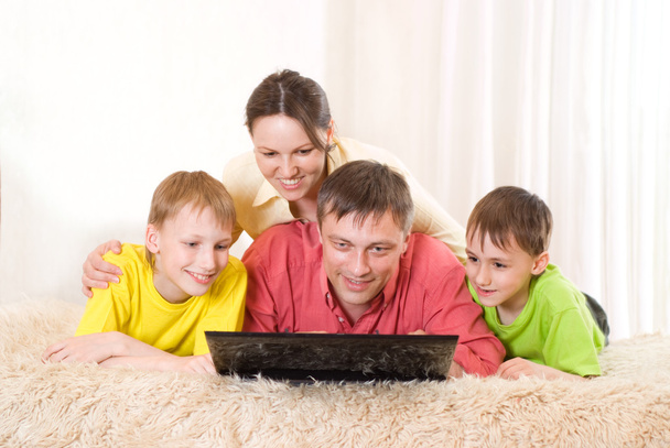 Família de quatro com um laptop
 - Foto, Imagem