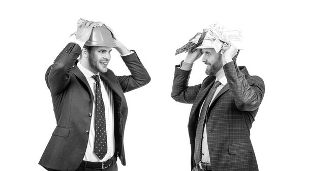 финансовая поддержка. инвестиции в архитектурный проект. двое мужчин в камуфляжной шляпе с деньгами. - Фото, изображение