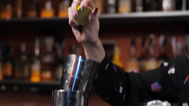 Przejście w ruchu Rudowłosa barmanka miesza batonik koktajlowy Margarita wyciskając świeży sok z limonki - Materiał filmowy, wideo