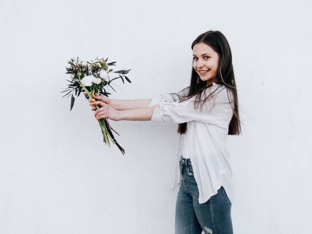 Happy florist girl with a bouquet of flowers - Photo, Image