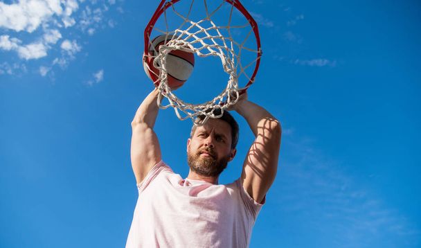 bebaarde man speler gooien basketbal door mand, sport hobby - Foto, afbeelding