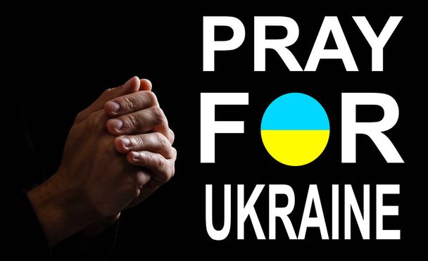 Bid voor ukraine. handen bidden op ukraine vlag - Foto, afbeelding
