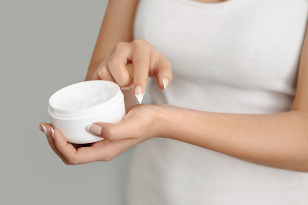 Closeup woman applying protective cream on hands. Hand skin care. Cosmetic cream. Beauty and body care concept - Photo, Image