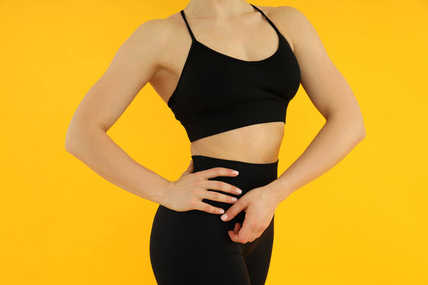Concept of healthy lifestyle with sporty woman on yellow background - Φωτογραφία, εικόνα