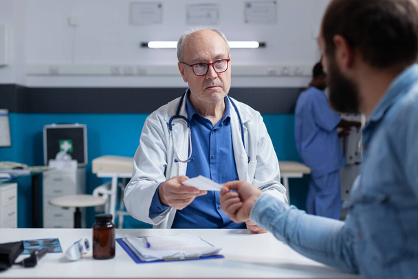 Médico que dá o arquivo de prescrição para o paciente doente na visita de check-up - Foto, Imagem