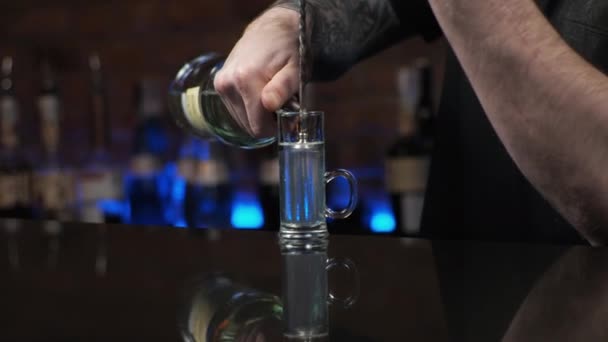 Barman is een jonge man De man schenkt drankjes in, bereidt alcoholische shots Medusa in de bar - Video
