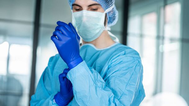 Ο γιατρός, βάζοντας προστατευτικά γάντια μπλε - Φωτογραφία, εικόνα