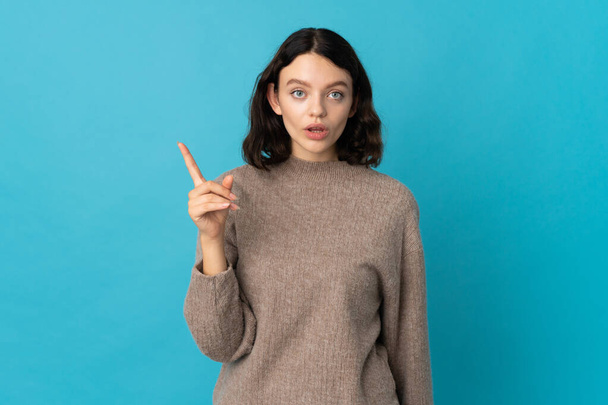 Teenager Ukrainian girl isolated on blue background intending to realizes the solution while lifting a finger up - Photo, image