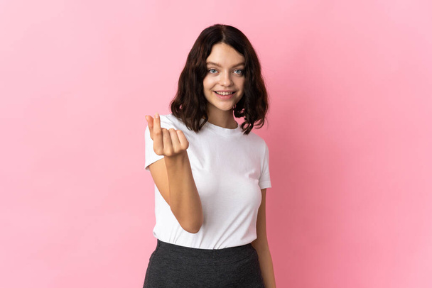 adolescente ucraina ragazza isolata su sfondo rosa fare soldi gesto - Foto, immagini