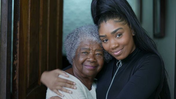 kleindochter omarmen senior grootmoeder authentieke familie liefde en omhelzing - Foto, afbeelding