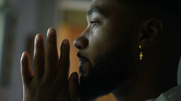 Созерцательный молодой человек молится Богу, человек из Африки Америки молится - Фото, изображение