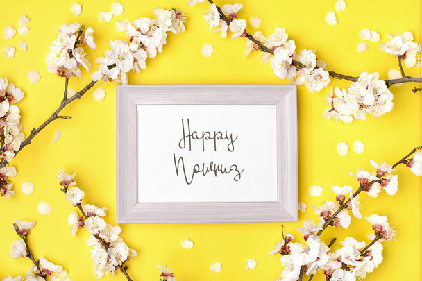 Sprigs of the apricot tree with flowers on yellow background Text Happy Nowruz Holiday Concept of spring came Top view Flat lay Hello march, april, may, persian new year. - Photo, Image