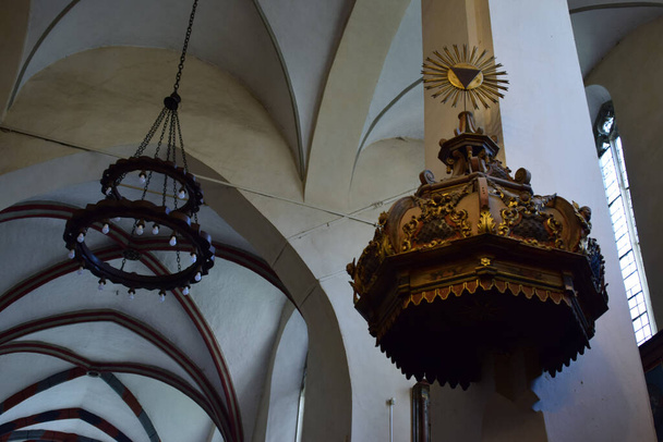 inside the catholic church from Sighisoara with organ, arches, roman rosettes, bell tower with statues with Christ and Romanian soldiers in a catholic ambiance as important as military architecture - Foto, afbeelding