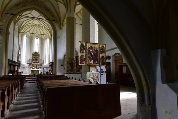 inside the catholic church from Sighisoara with organ, arches, roman rosettes, bell tower with statues with Christ and Romanian soldiers in a catholic ambiance as important as military architecture - Foto, Imagen