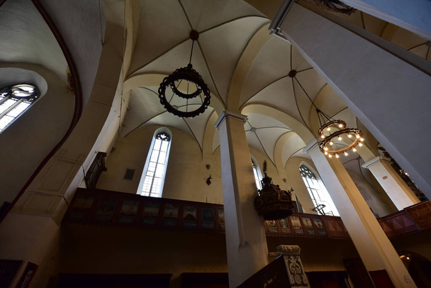 inside the catholic church from Sighisoara with organ, arches, roman rosettes, bell tower with statues with Christ and Romanian soldiers in a catholic ambiance as important as military architecture - Foto, afbeelding