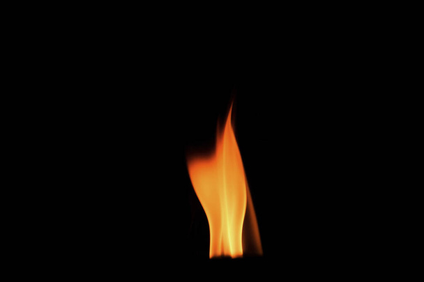 Nahaufnahme brennender Flammen auf schwarzem Hintergrund für Grafikdesign oder Tapeten. Rot und gelb, Heizenergie, die den Brennstoff in der Nacht entzündet. Abstraktes Feuer zum Kochen. - Foto, Bild