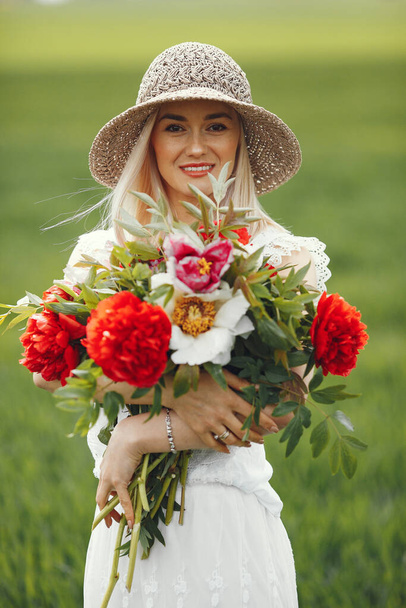 Woman in elegant dress standing in a summer field - Foto, Bild