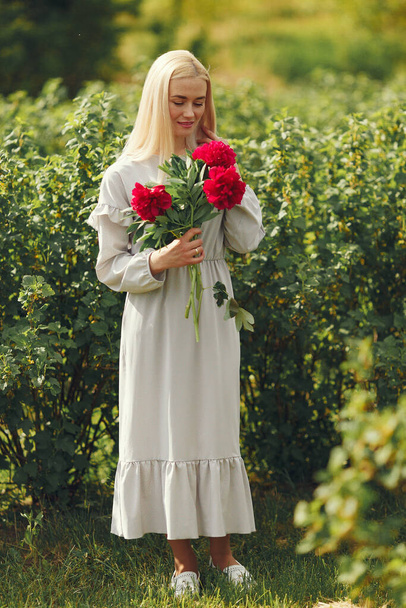 Woman in elegant dress standing in a summer field - Fotografie, Obrázek