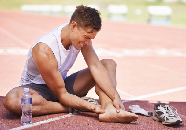 Tienes que romperte antes de que puedas acumularte. Tiro de un atleta sintiendo el dolor de una lesión en el tobillo. - Foto, Imagen