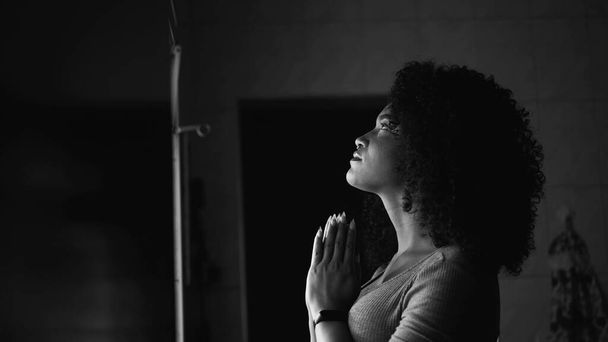Nainen rukoilee kotona ikkunassa ottaa HOPE ja FAITH yksivärinen - Valokuva, kuva