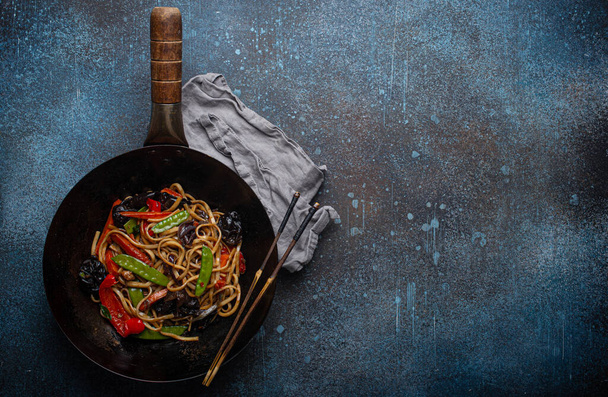 Fideos salteados asiáticos con verduras en espacio de copia wok pan negro - Foto, Imagen