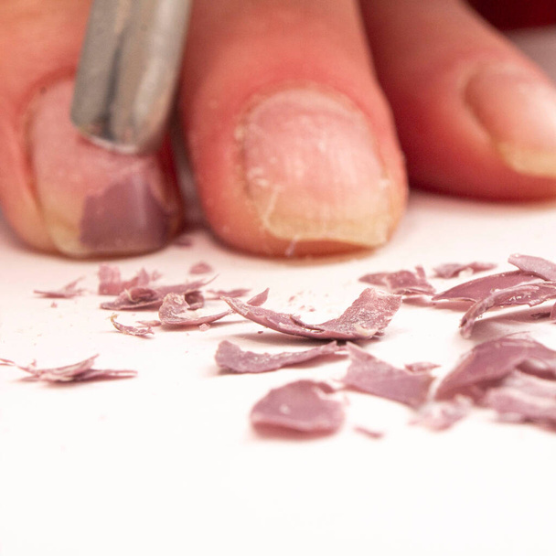 remoção de unhas estendidas dos dedos da menina mecanicamente usando um raspador de ferro - Foto, Imagem