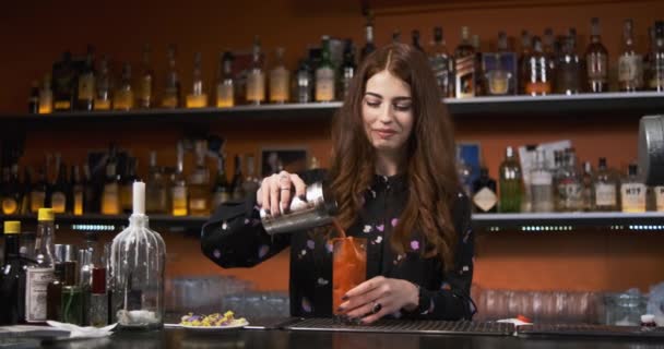 roodharige meisje jong volwassen vrouw barman bereidt mixen bloederige vrolijke cocktail aan de bar - Video