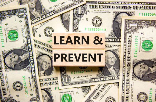 Learn and prevent symbol. Concept words Learn and prevent on wooden blocks on a beautiful background from dollar bills. Business learning and learn and prevent concept, copy space. - Photo, Image